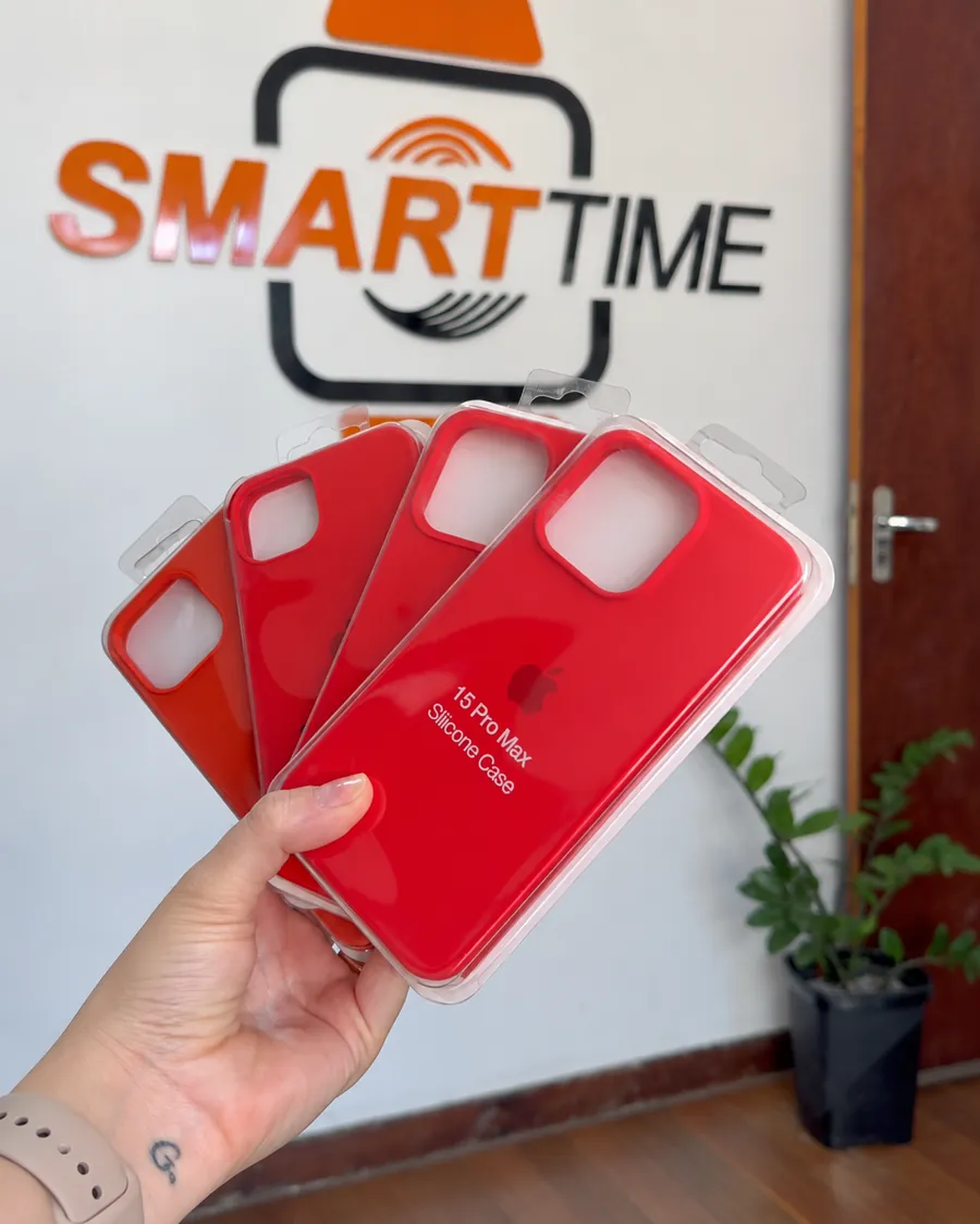 Mão segurando capas de silicone vermelhas em frente ao logo da SmartTime